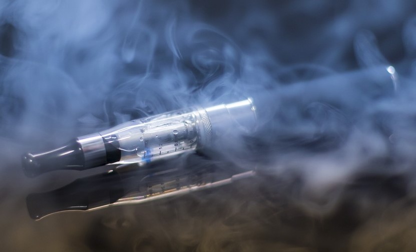 Imagen de un cigarrillo electrónico rodeado de vapor.